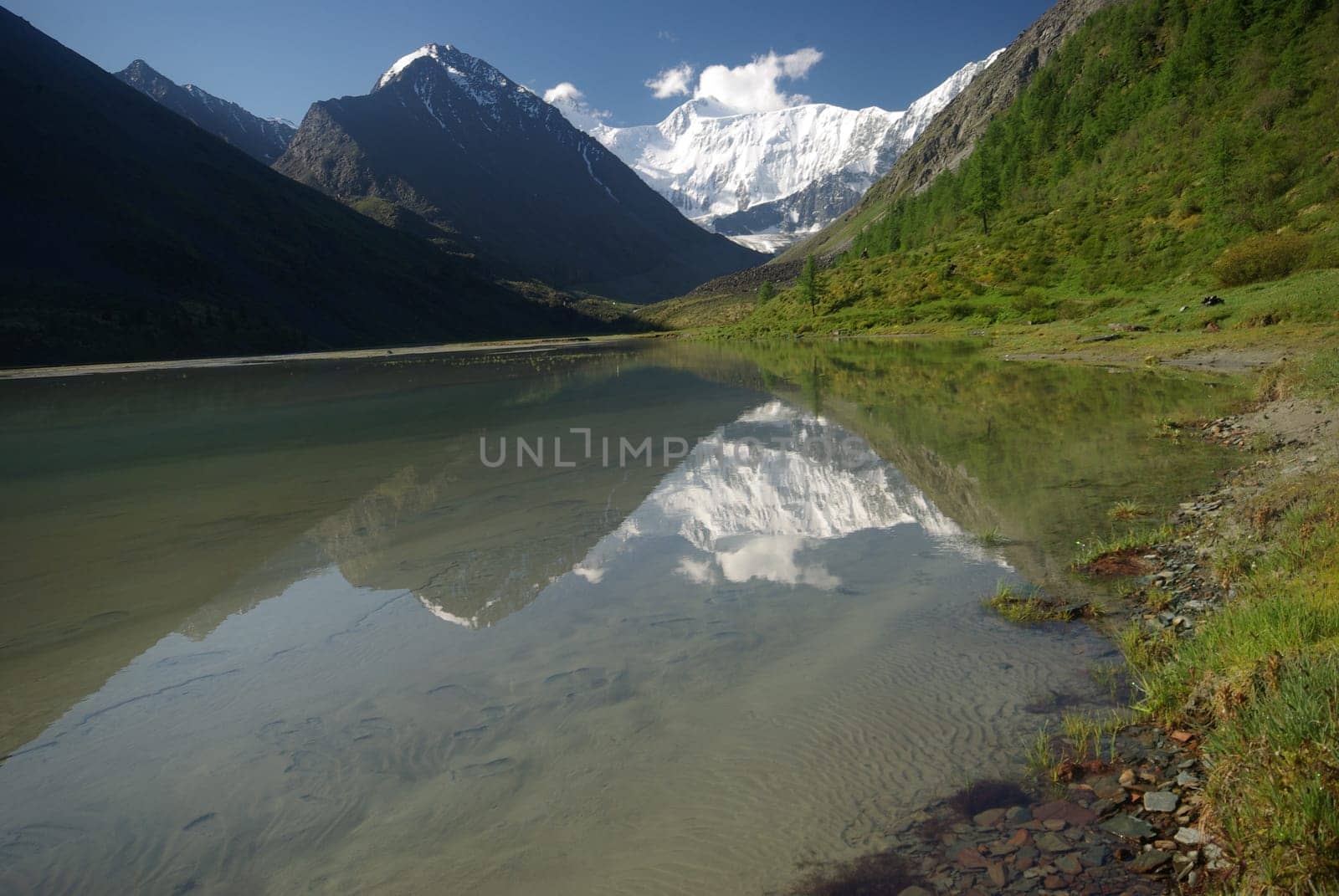 The mountain river in the mountains. Current through the gorge the river. Stones and rocky land near the river. Beautiful mountain landscape.
