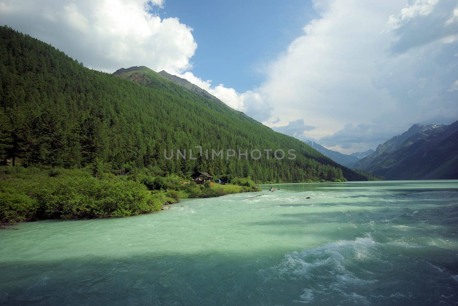 The mountain river in the mountains. Current through the gorge the river. Stones and rocky land near the river. Beautiful mountain landscape.