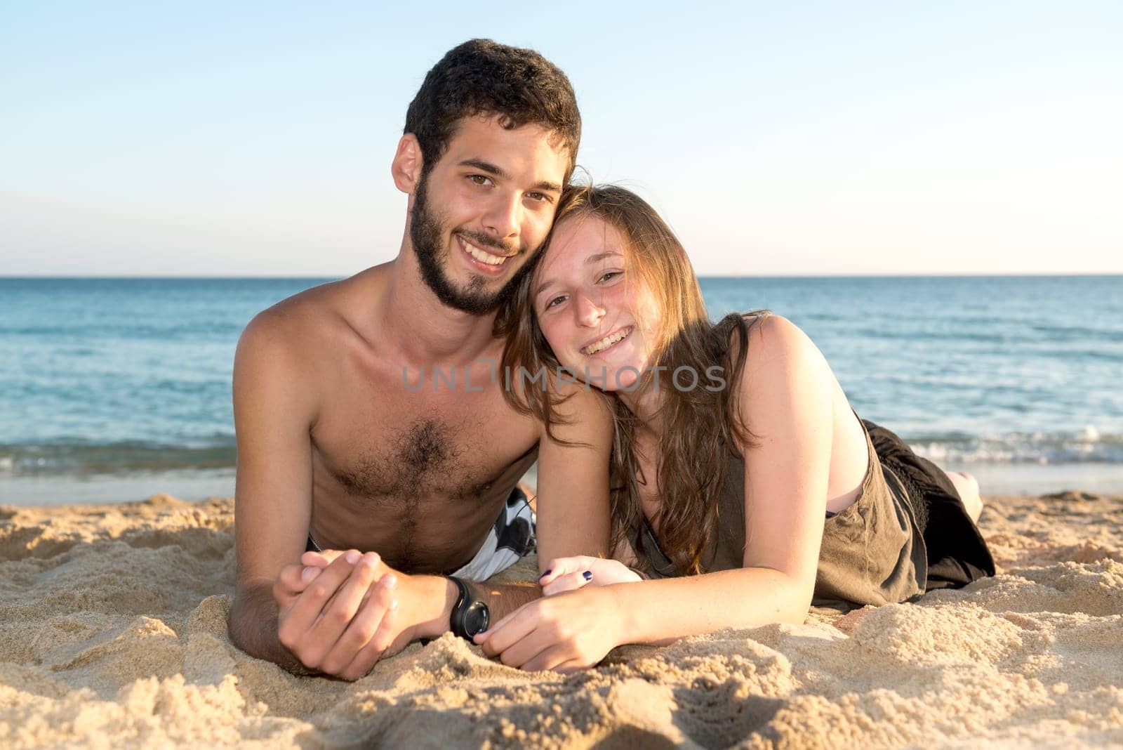Happy young couple posing in the beach