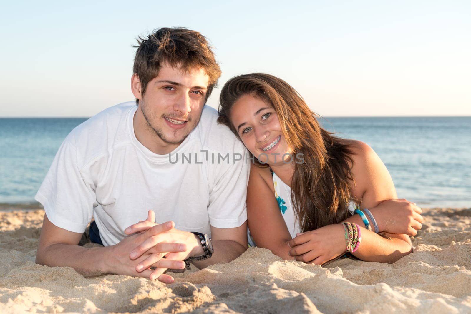 Happy young couple posing in the beach