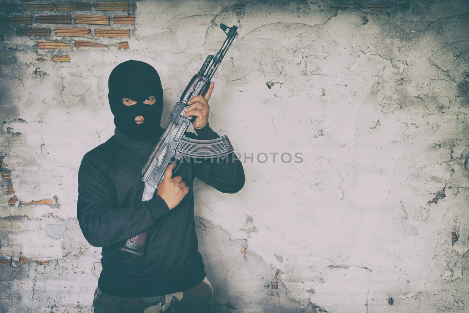terrorist in black uniform and mask with kalashnikov ak47