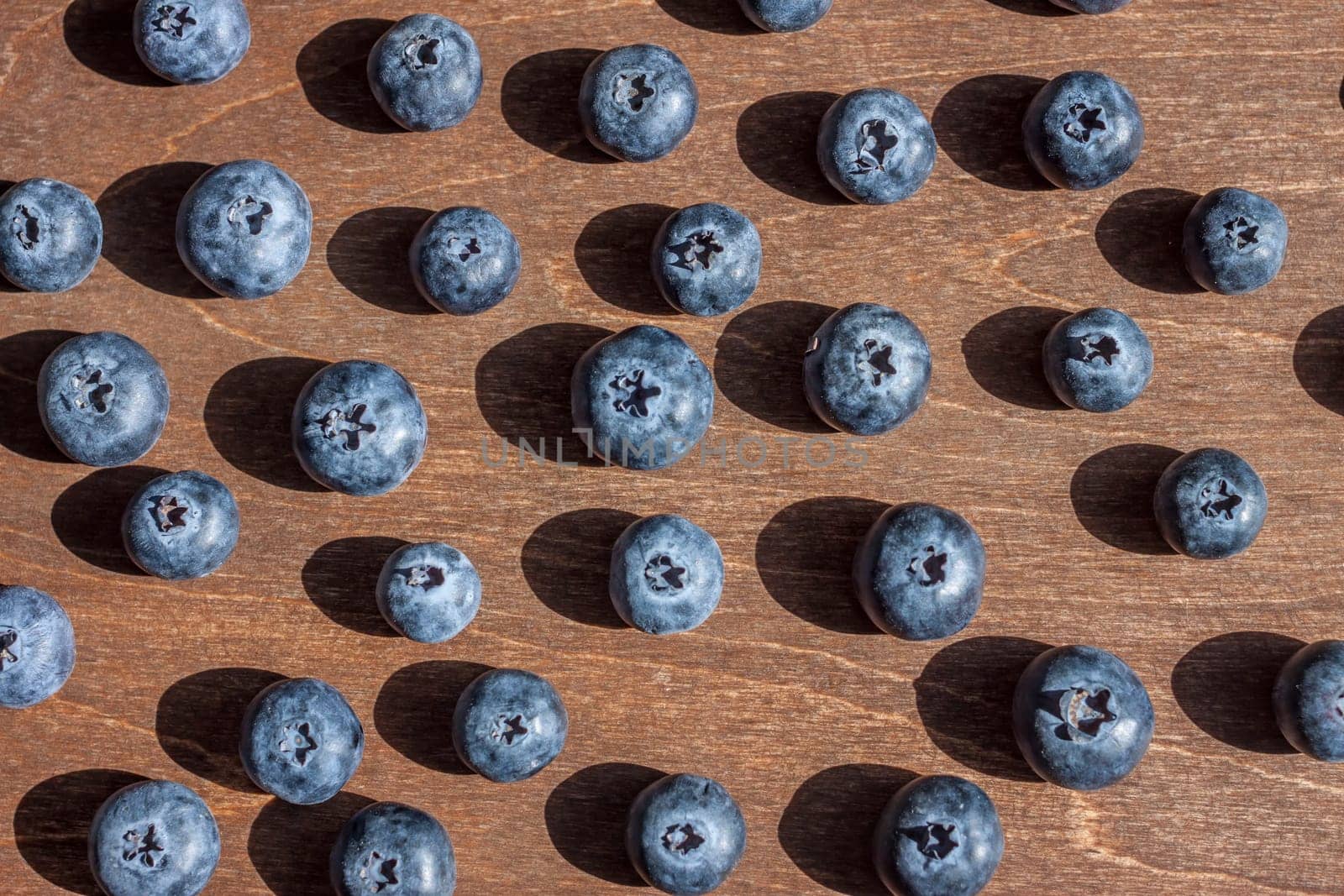 fresh big delicious blueberries wooden background bright shadows