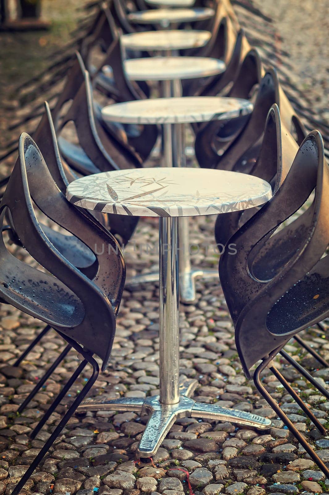 Tables and chairs lined up outdoors in a public place. Selective focus.