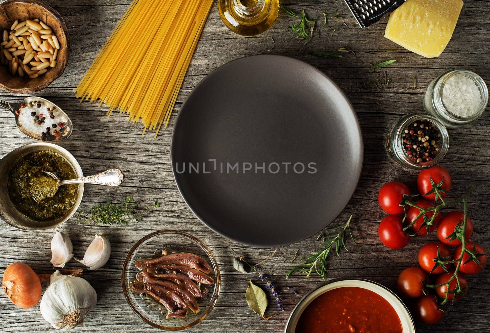 Spaghetti with ingredients for cooking pasta on wooden background