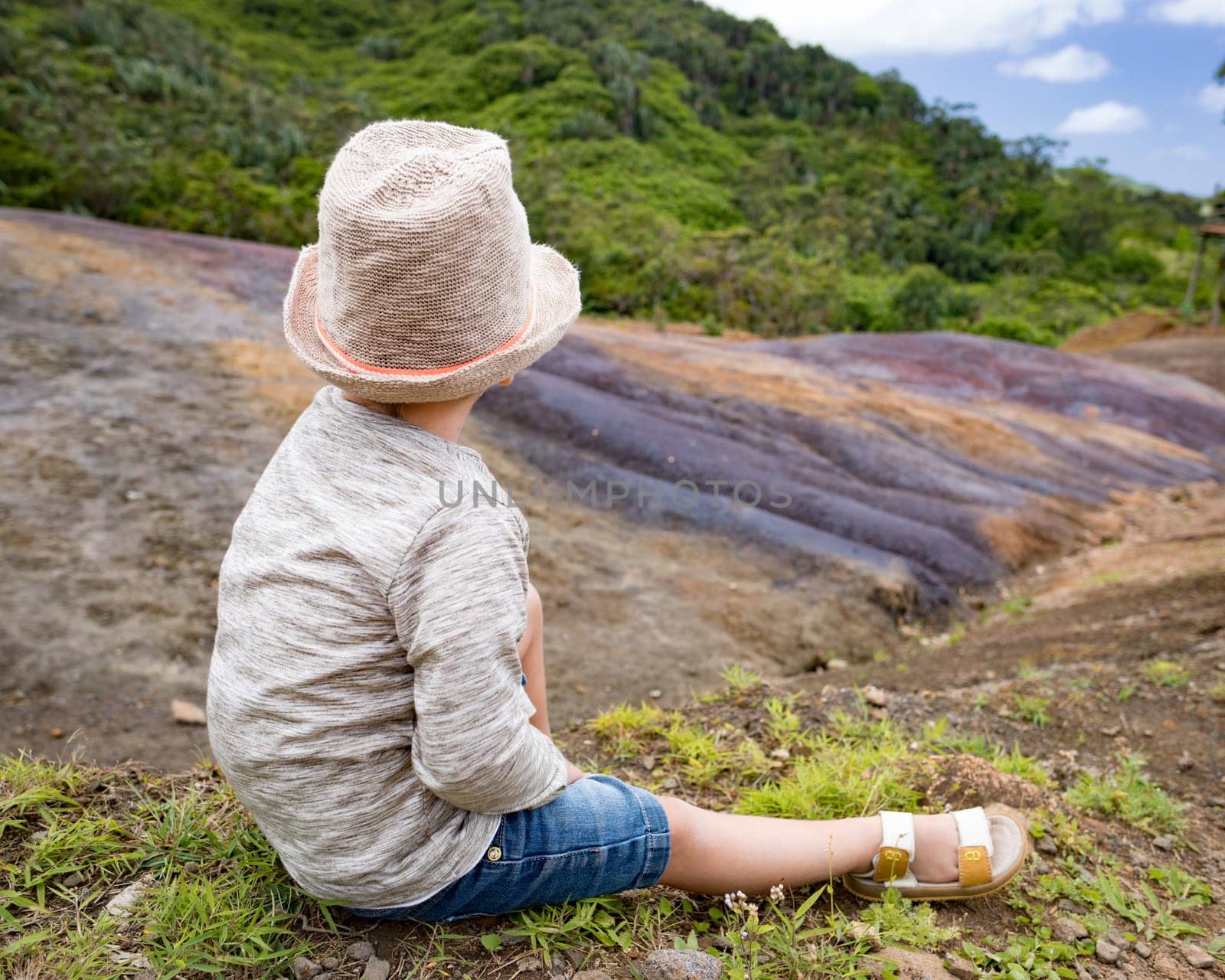 Boy looking coloured earth. Mauritius.