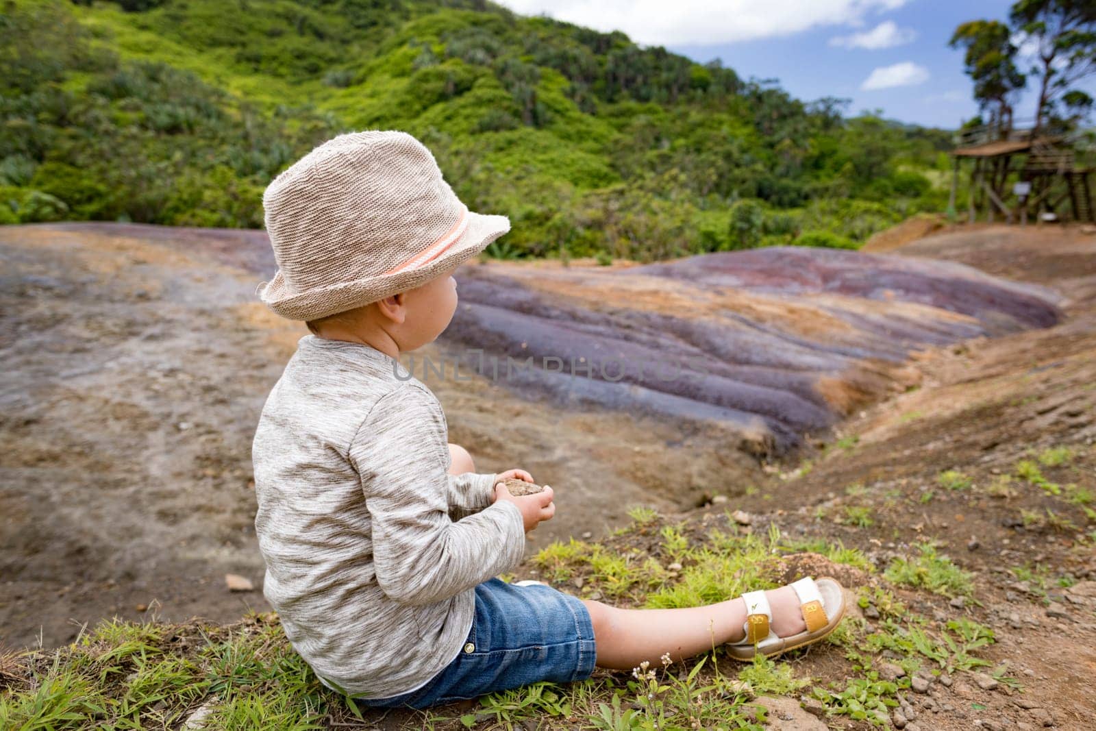 Boy looking coloured earth. Mauritius.