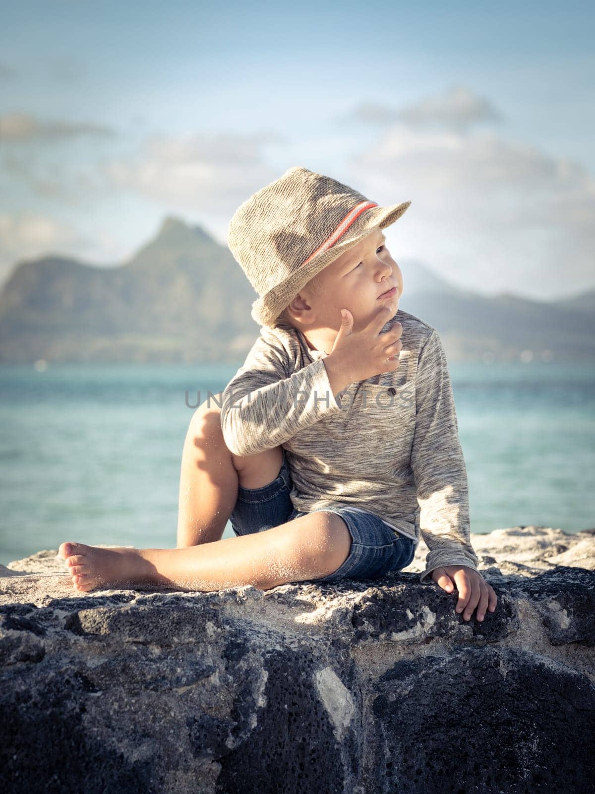 Child  looking into the distance on the beach at sunset time
