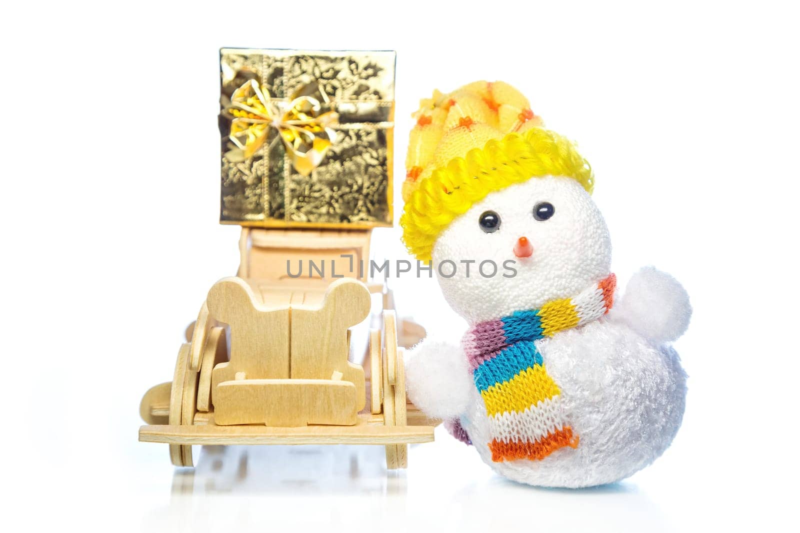 Christmas snowman toy and old vintage wooden automobile with golden or yellow gift box on white background. Main focus of image on Santa Claus and selective on wood car