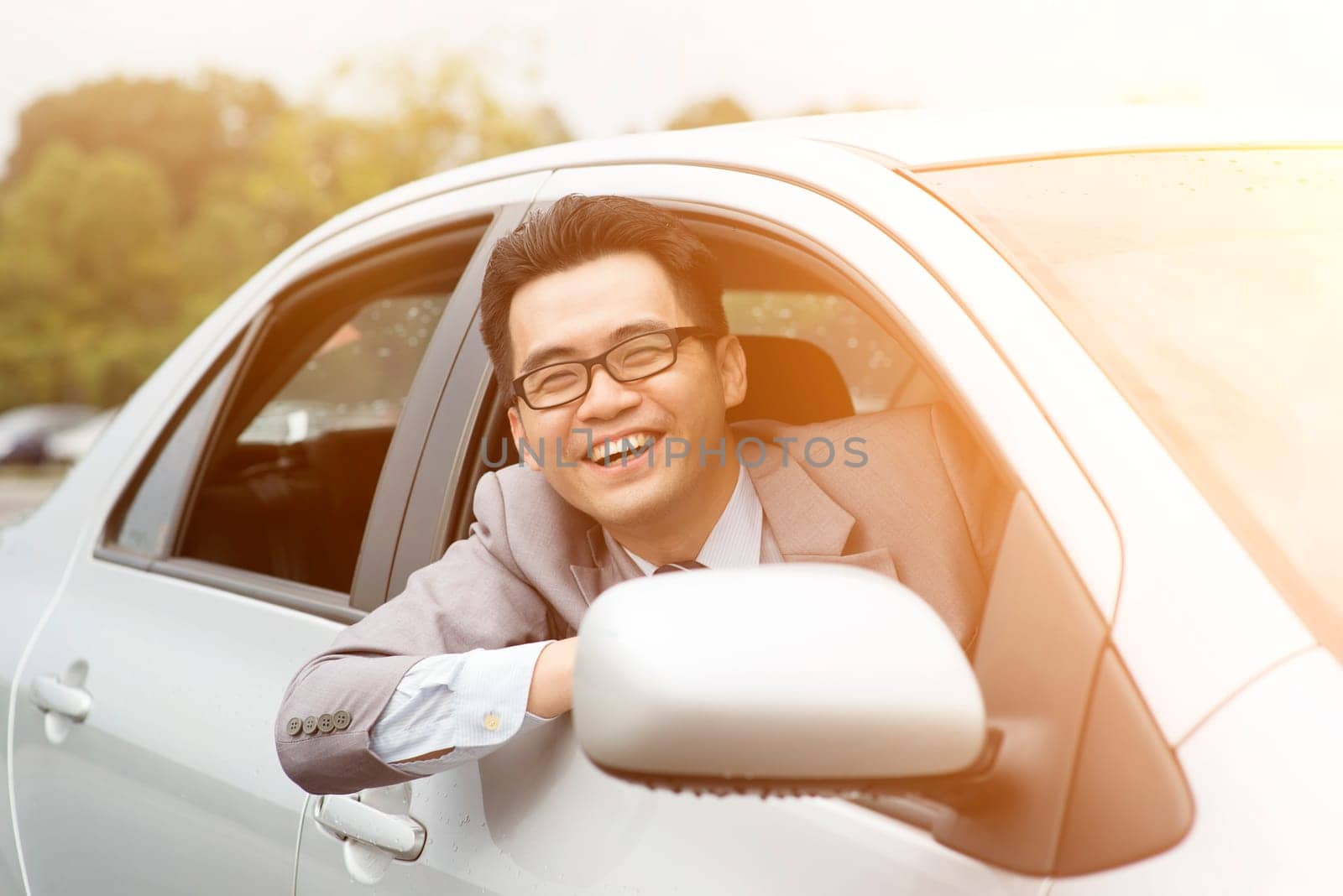 Happy driver sitting in his car and smiling.