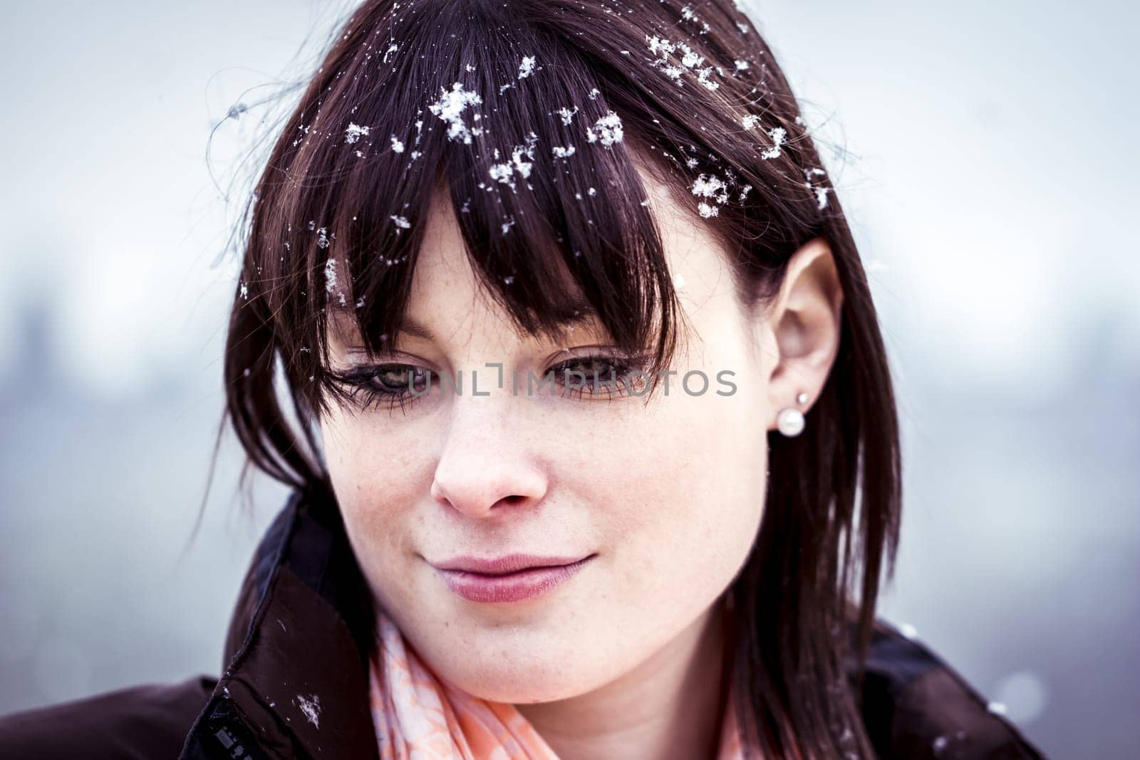The young woman feels alone. She has snow in her hair and a lot of sorrows in her beautiful face.