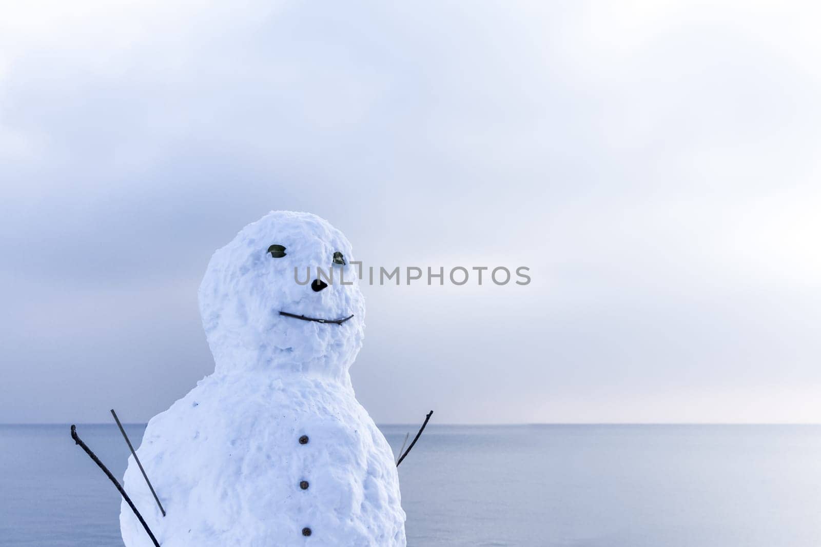 Traditional man of snow at a cool and snowy sea scene.