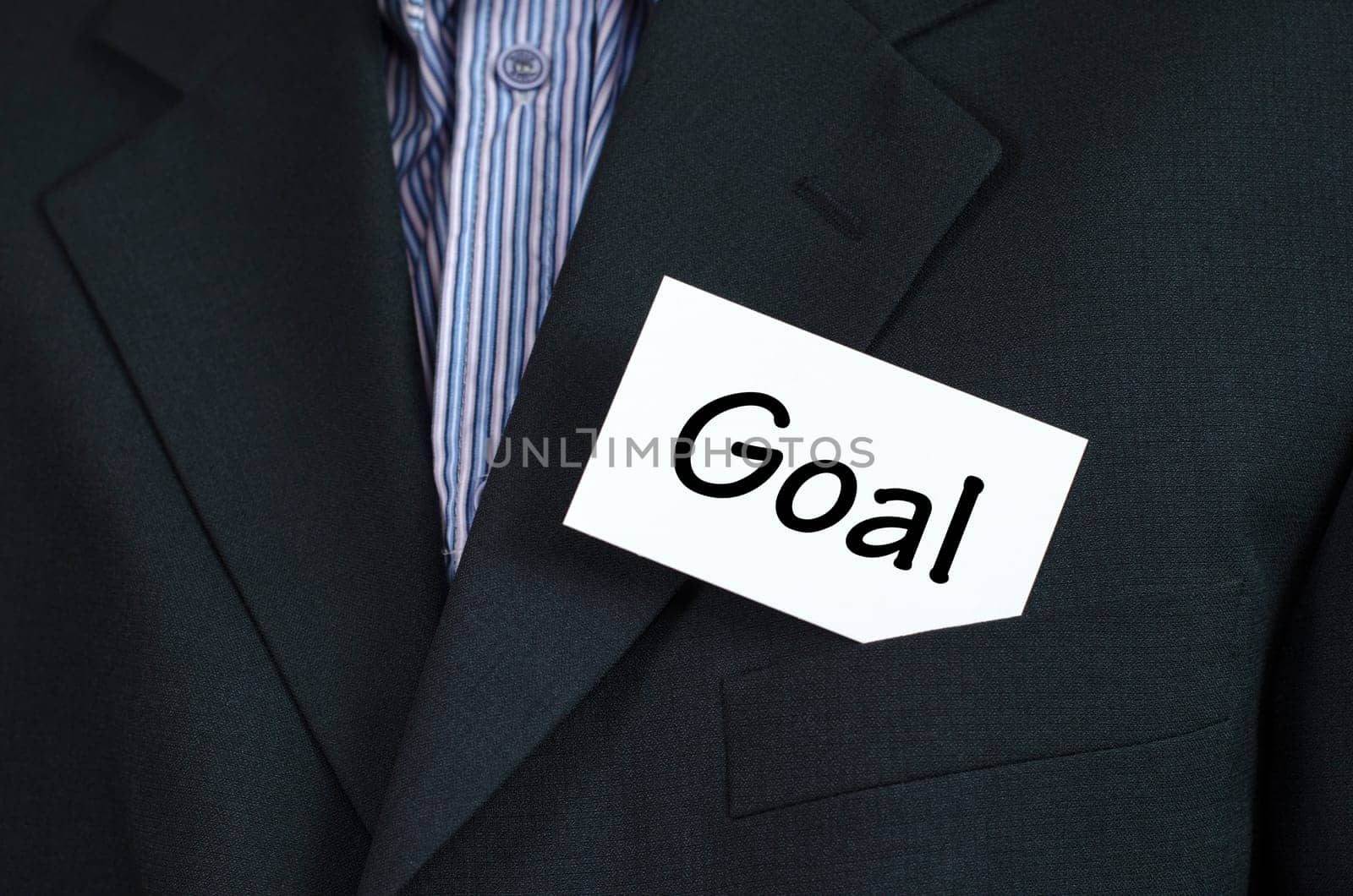 Goal text note concept over business man background.