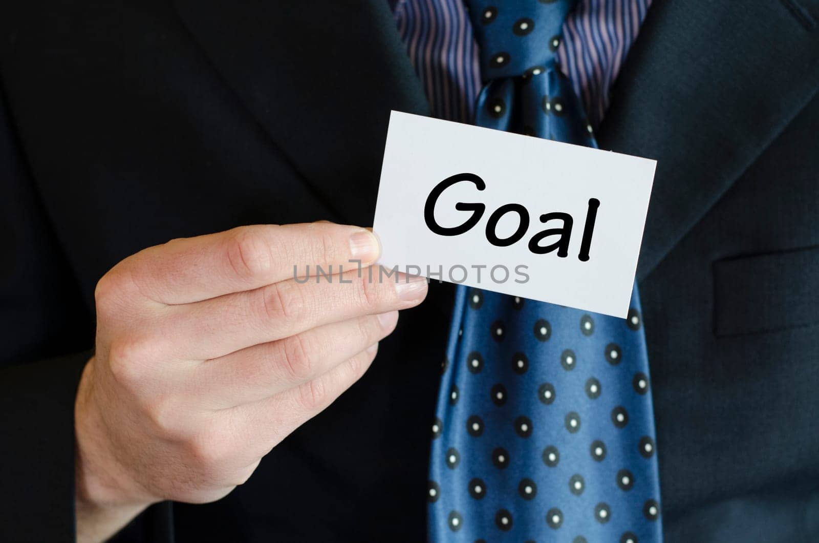 Goal text note concept over business man background.