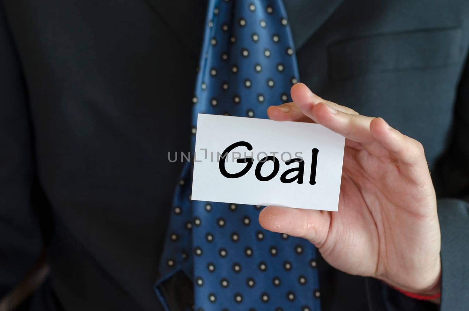 Goal text note concept over business man background.
