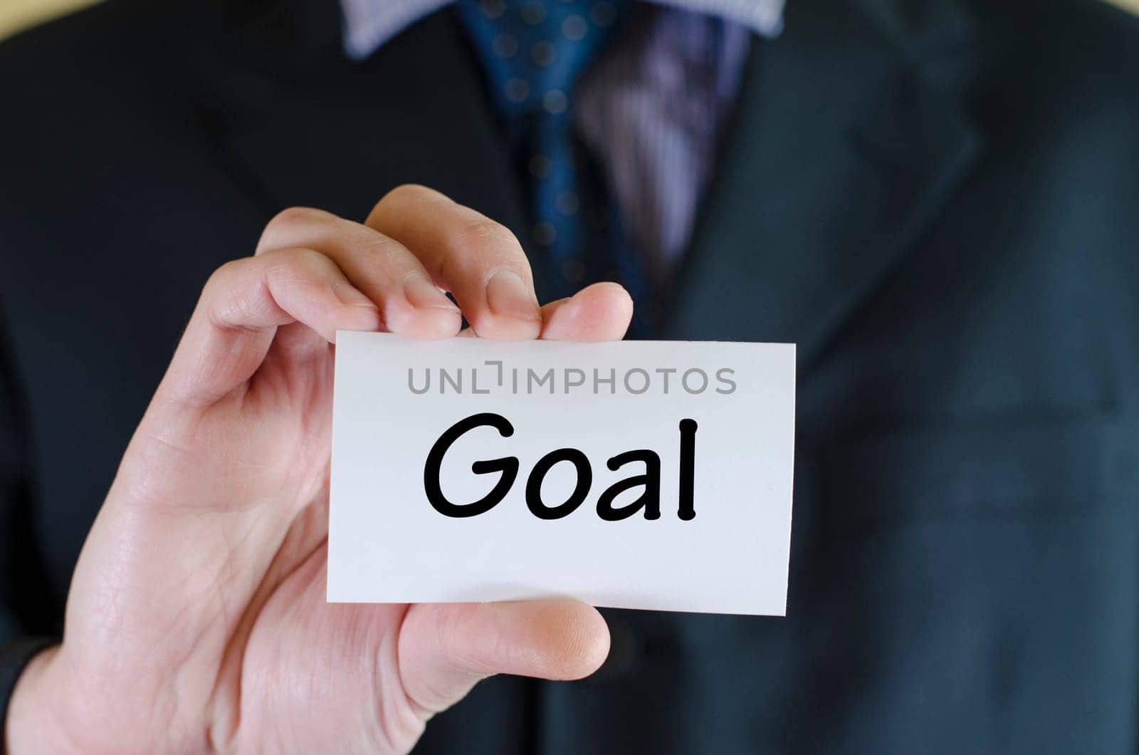 Goal text note concept over business man background.