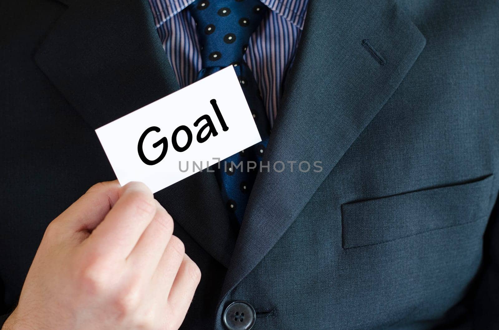 Goal text note concept over business man background.