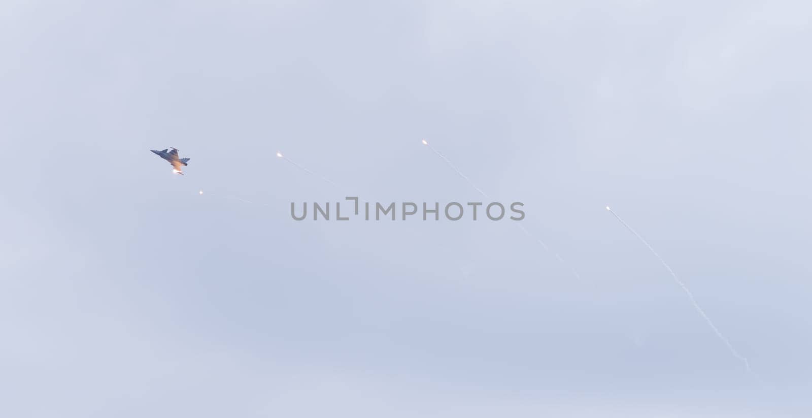 LEEUWARDEN, NETHERLANDS - JUNE 6, 2016: Modern tactical fighter jet JAS-39 Gripen fires flares during the Royal Dutch Air Force open days.
