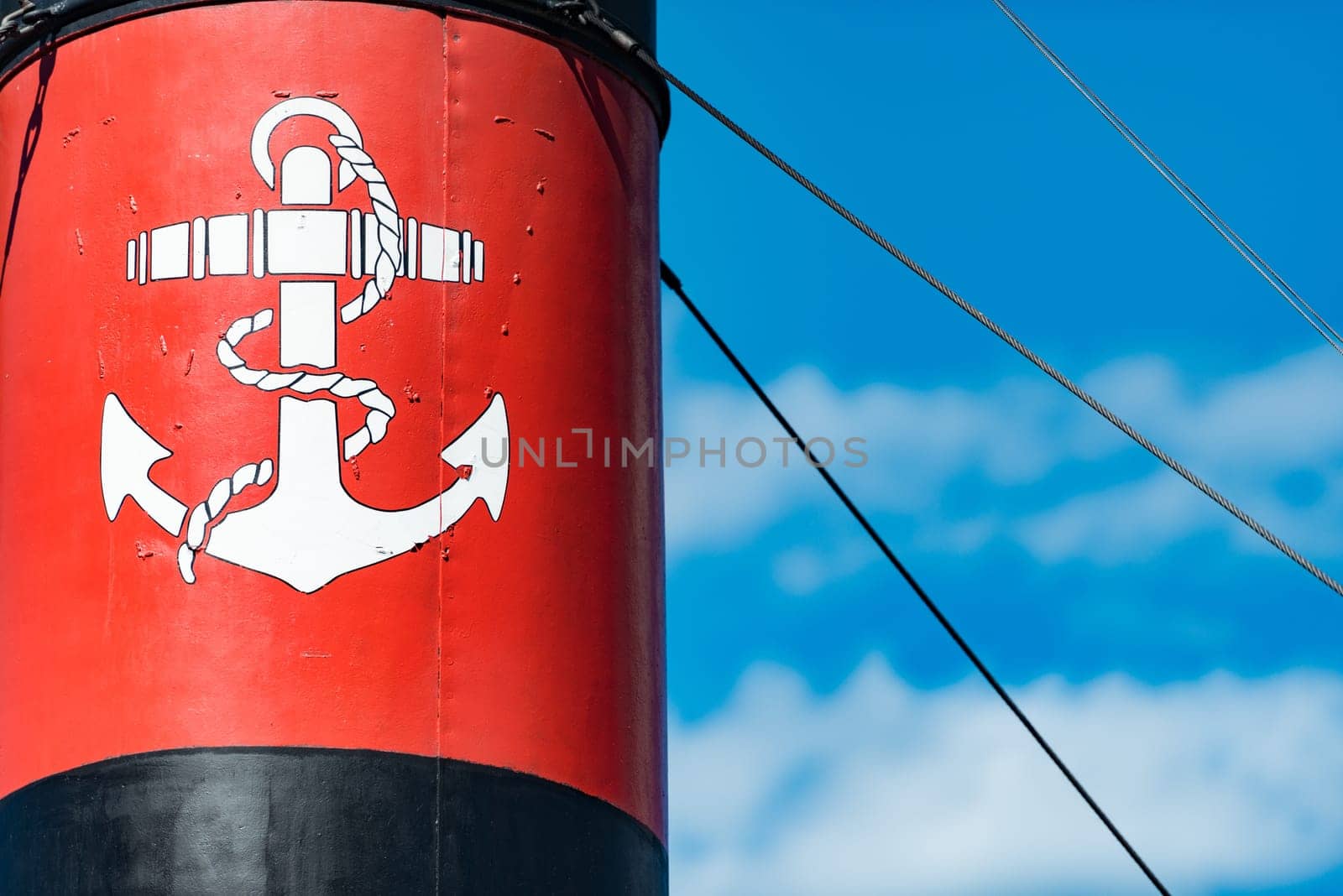 Old ship funnel with anchor sign in foreground and summer sky in background. Stockholm, Sweden, Scandinavia, Europe.