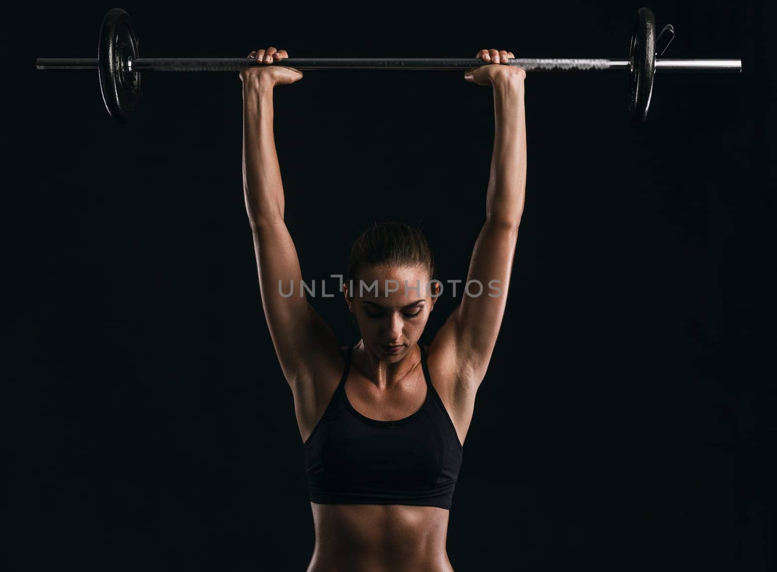 Shot of a beautiful young woman in a workout gear lifting weights