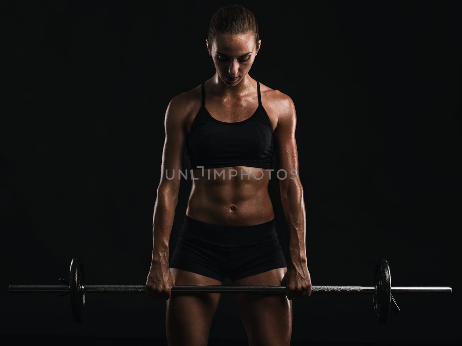 Shot of a beautiful young woman in a workout gear lifting weights