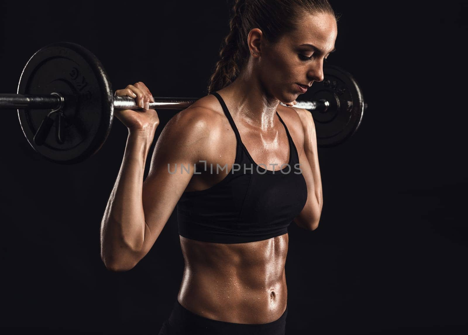 Shot of a beautiful young woman in a workout gear lifting weights