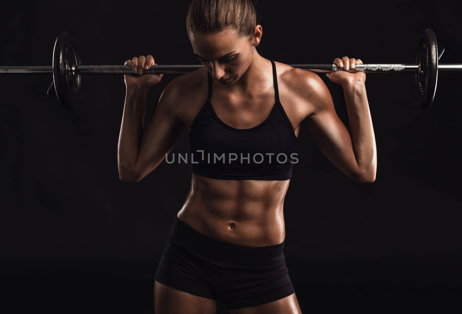 Shot of a beautiful young woman in a workout gear lifting weights