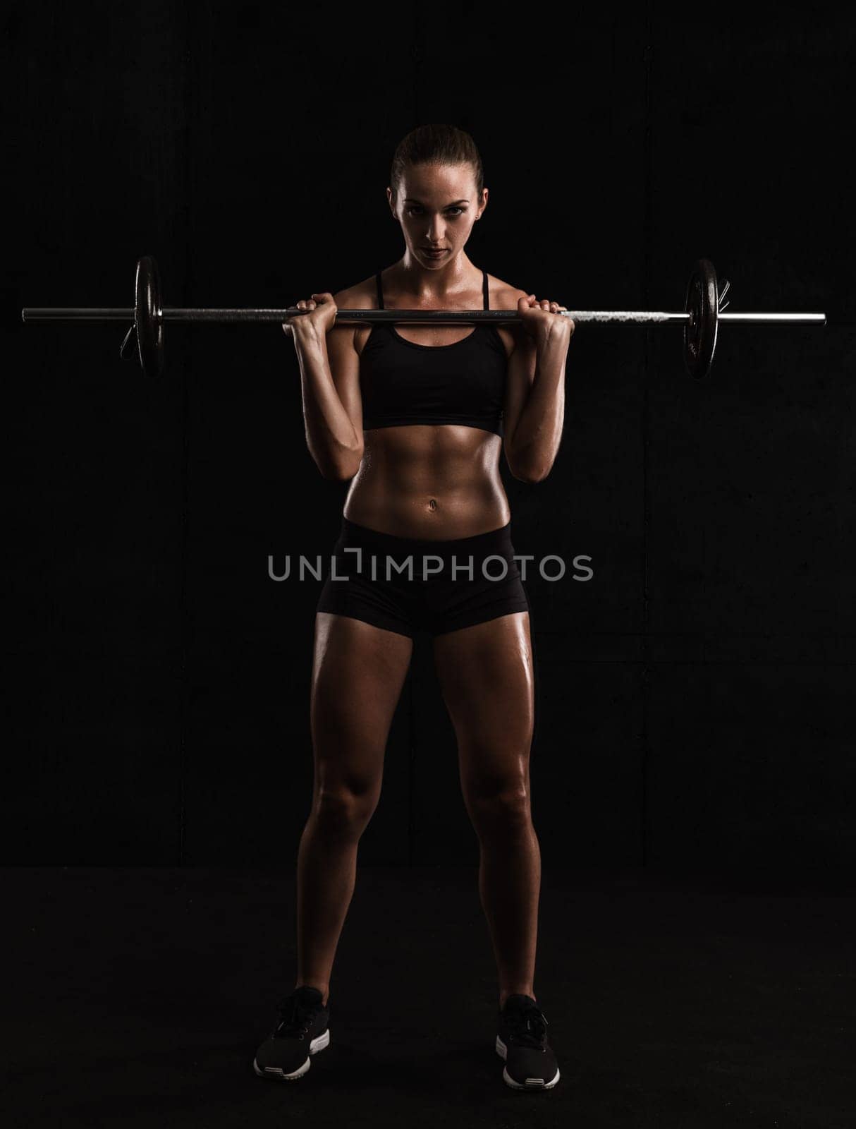 Shot of a beautiful young woman in a workout gear lifting weights