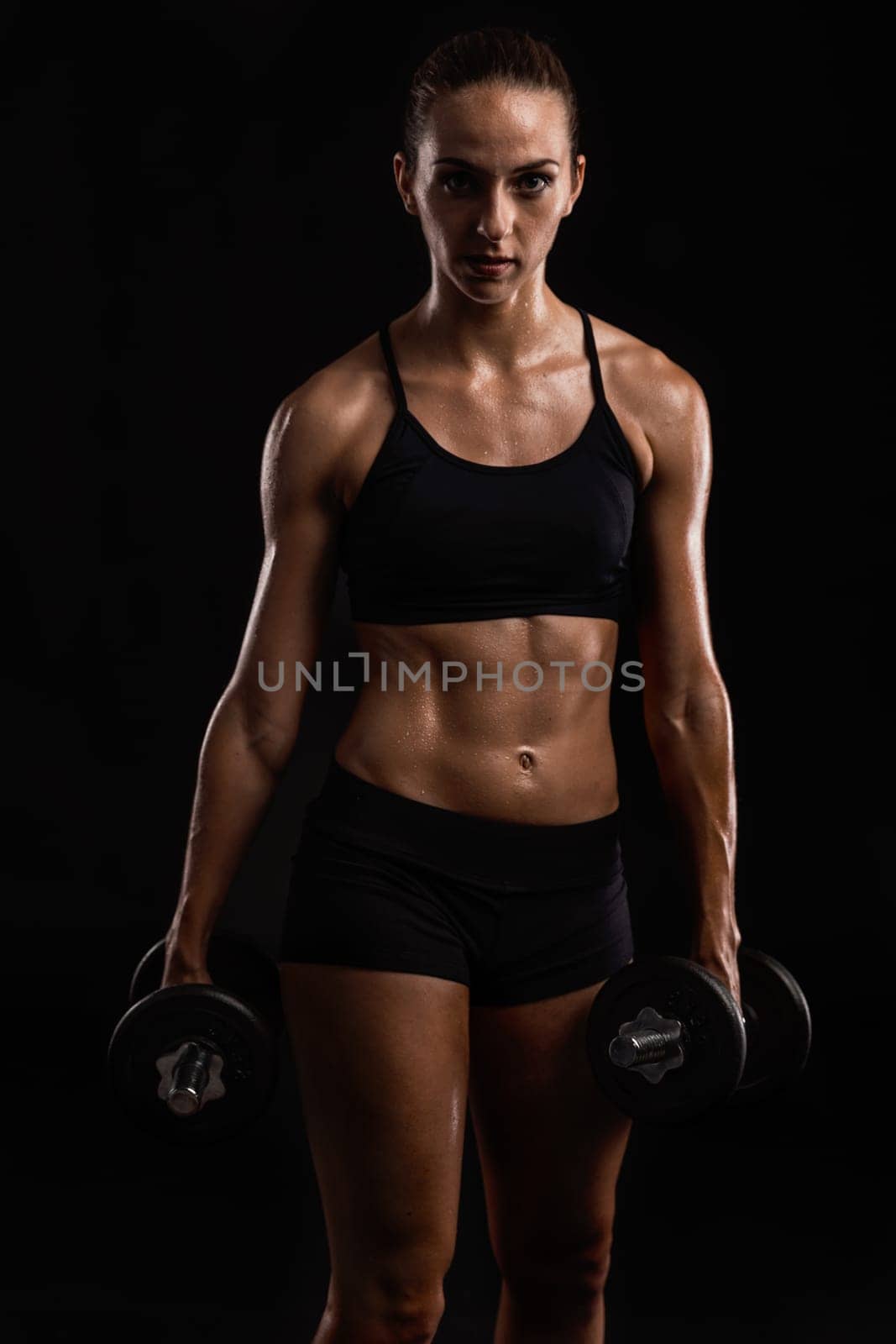 Studio portrait of a sporty young woman posing against a dark background