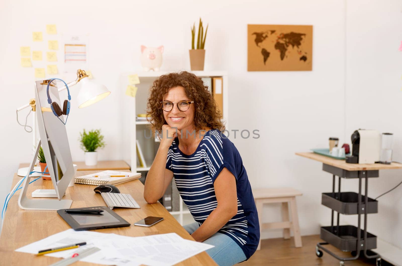 Middle age designer working on a desktop at her office