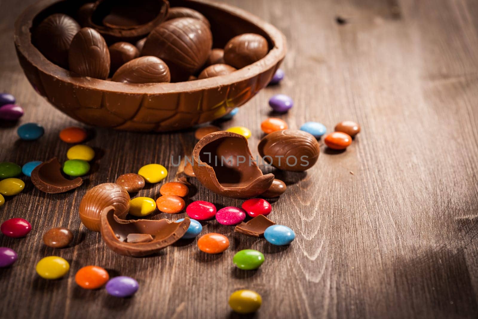Assorted chocolate eggs for Easter on wooden background