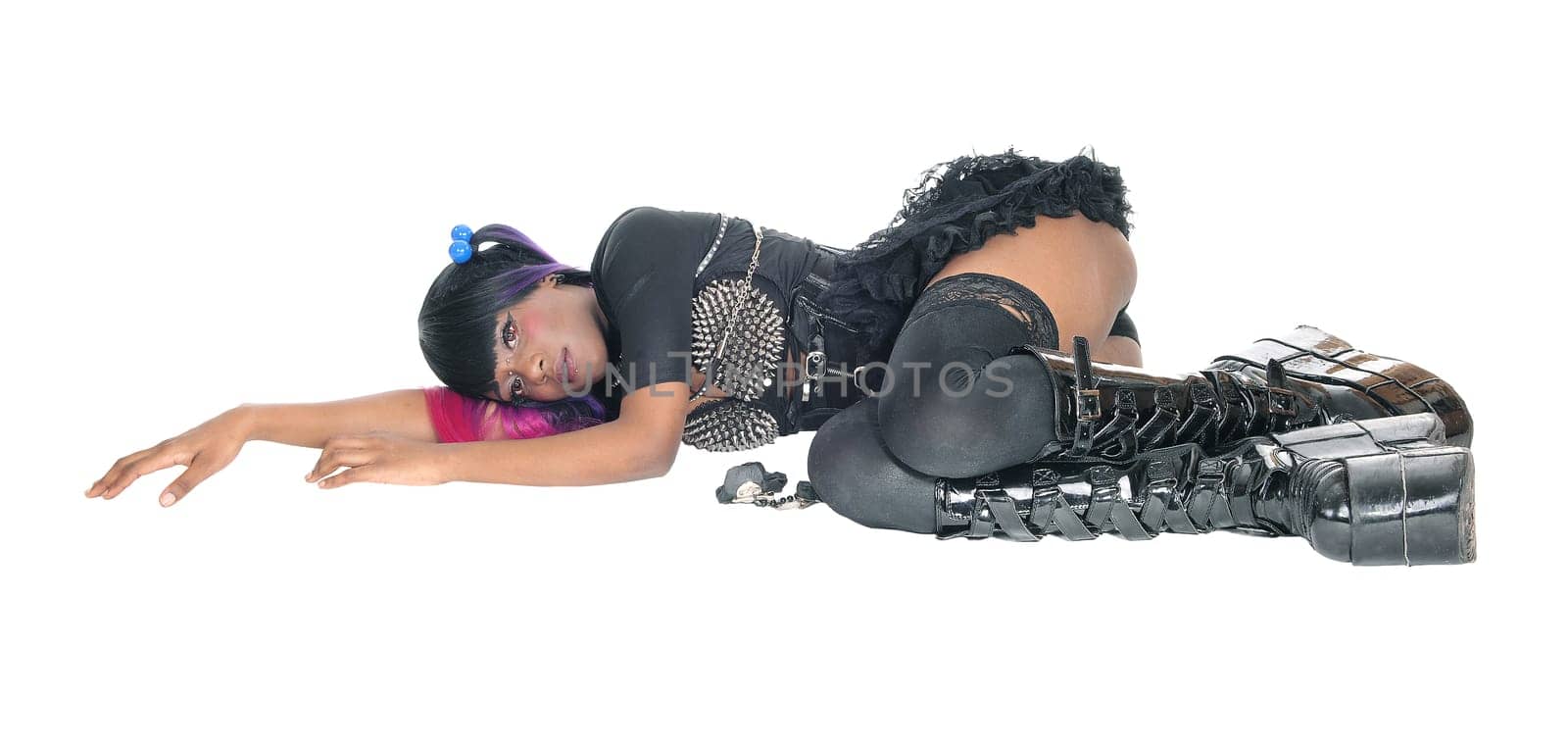 A young steam punk African American woman in a short skirt and long.boots lying on the floor, isolated for white background..