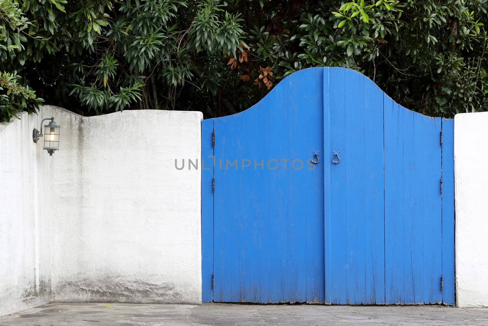 Old wooden blue gateway with white wall