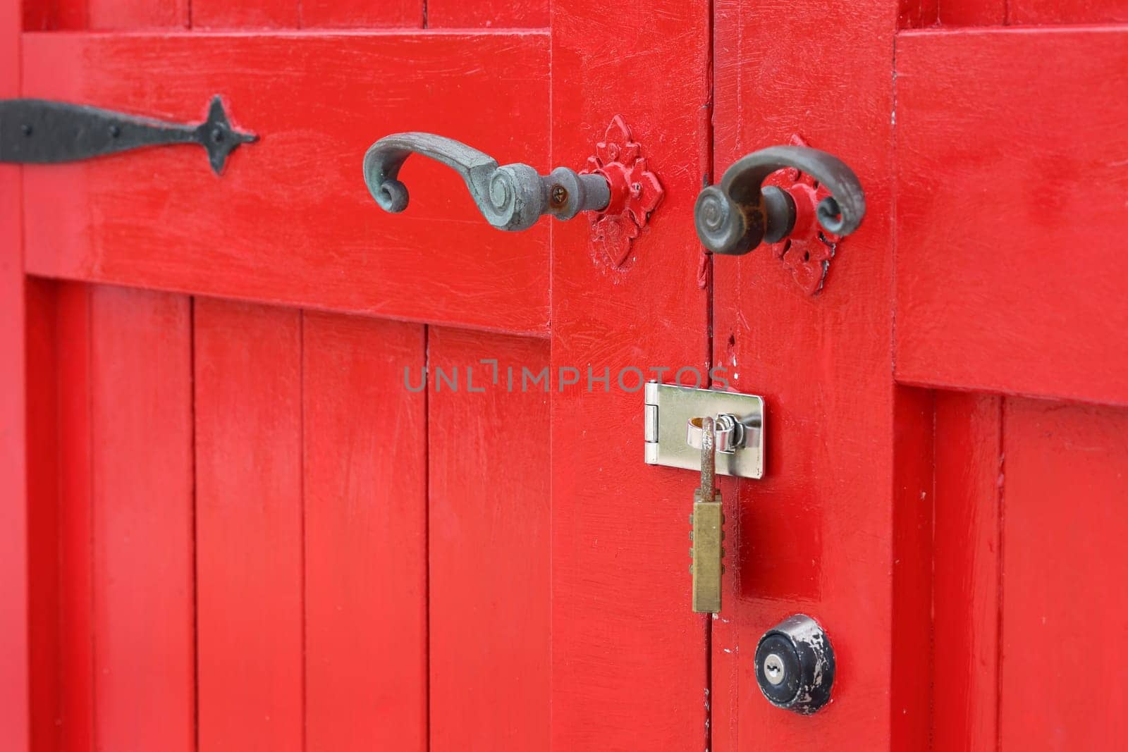 closeup of old wooden red door with metal handle