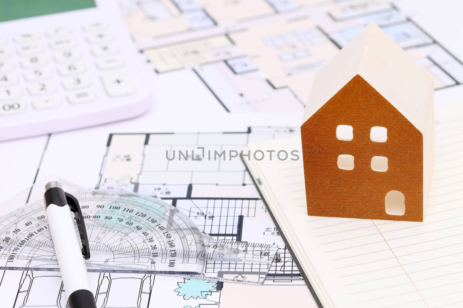Miniature model of house and blueprints