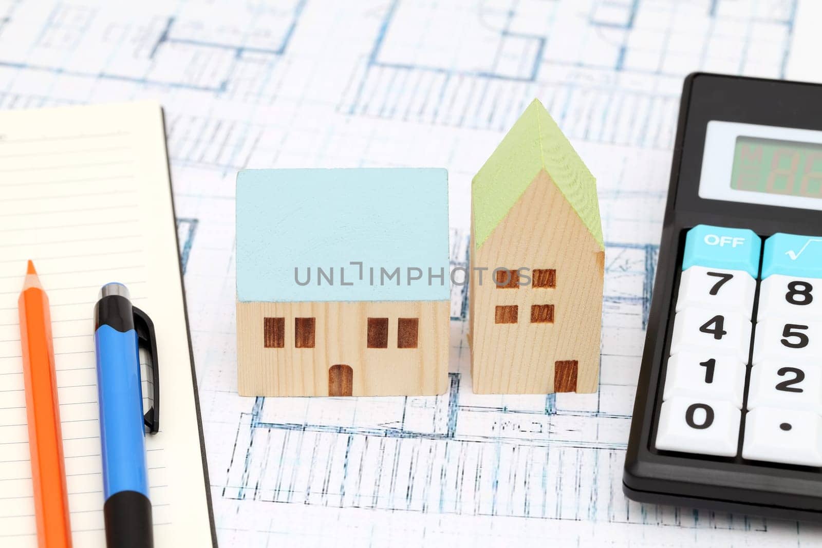 Miniature model of house on blueprints, construction plan