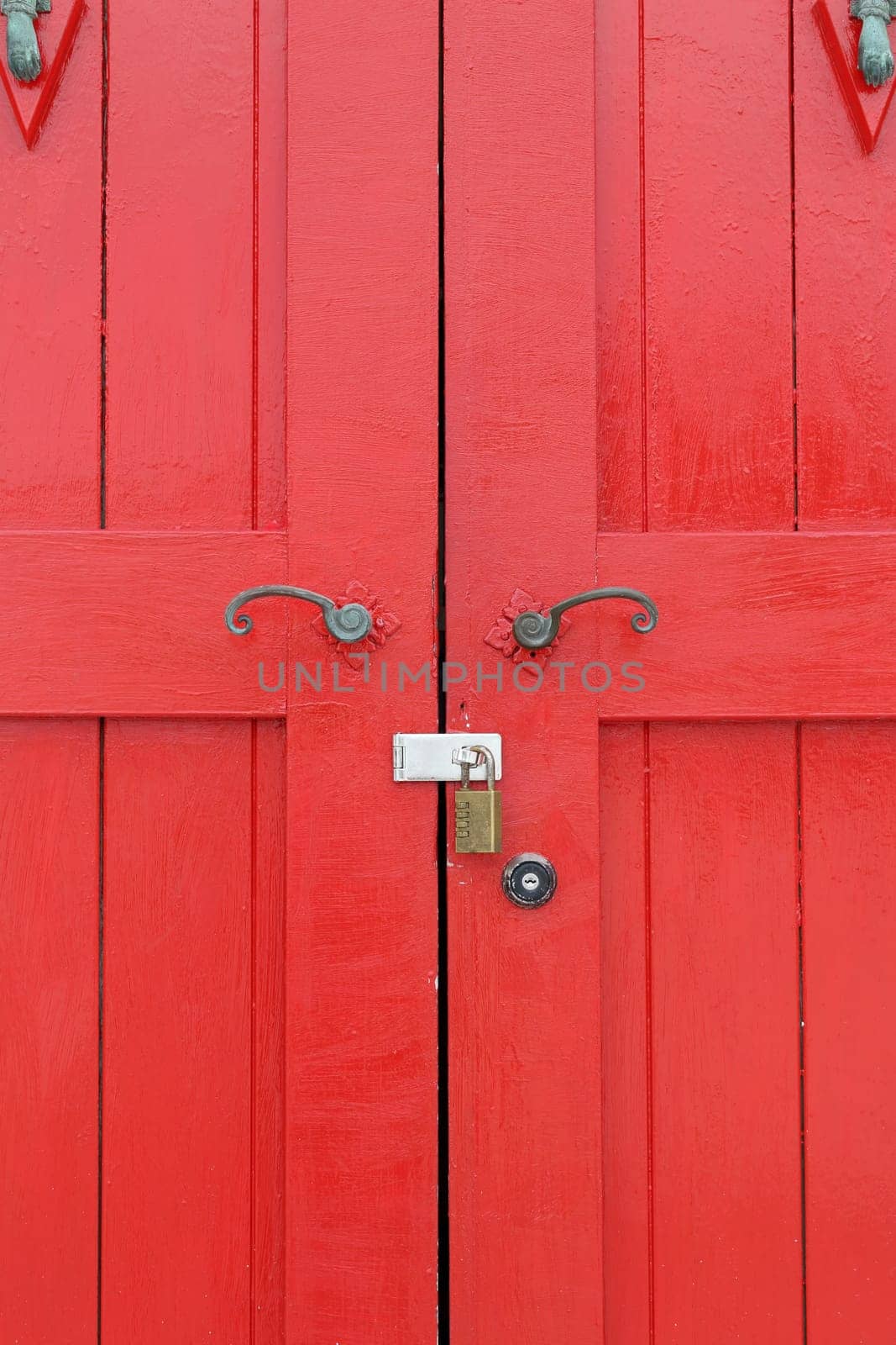 closed old wooden red door with metal handle