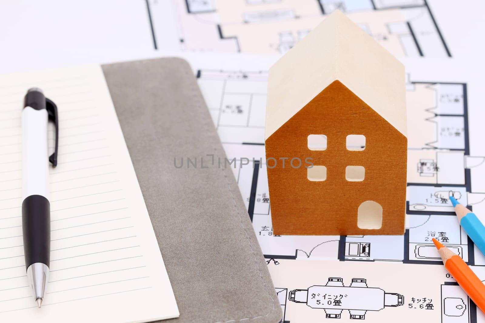 Miniature model of house on blueprints, construction plan