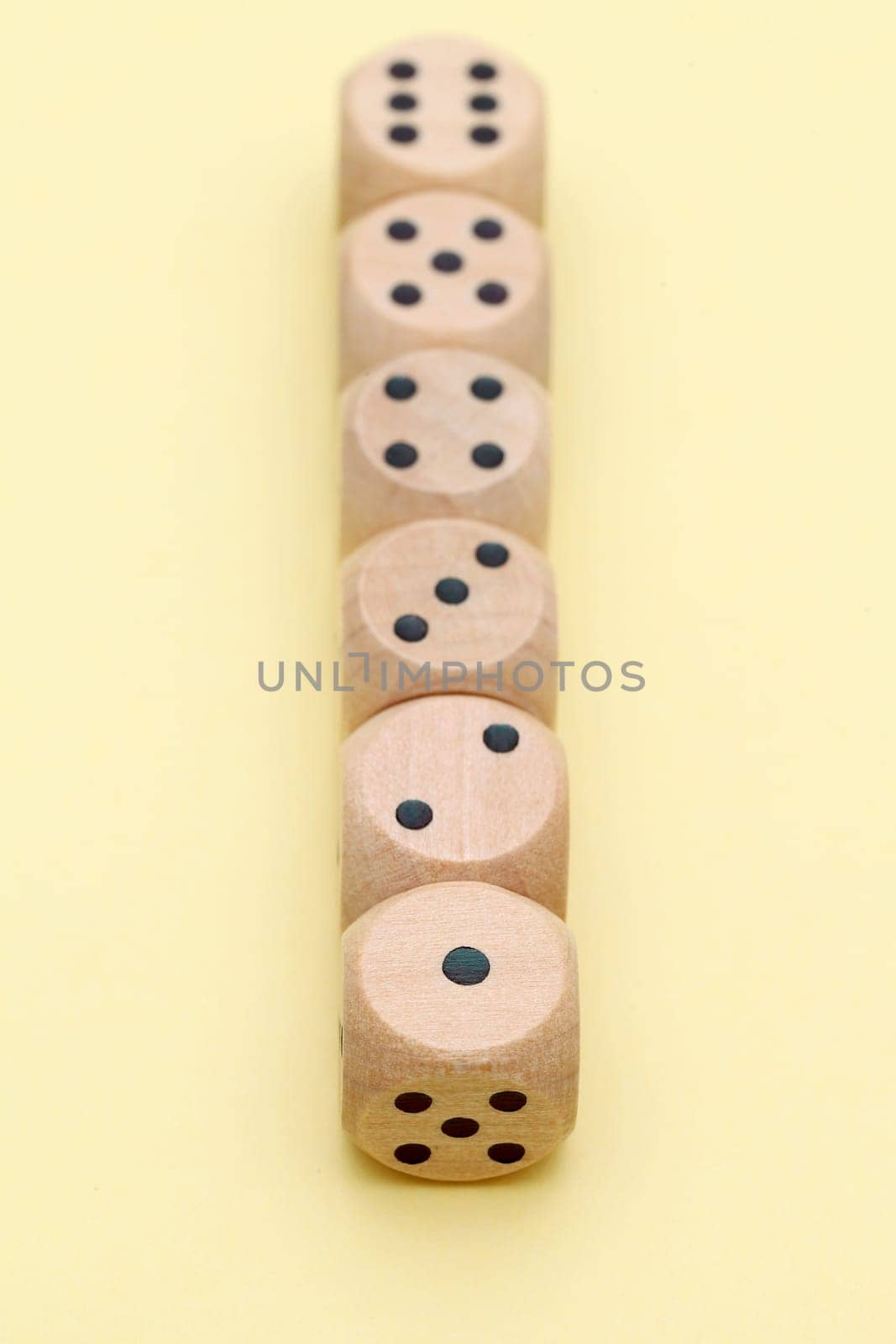 Wooden dice in a row on yellow background