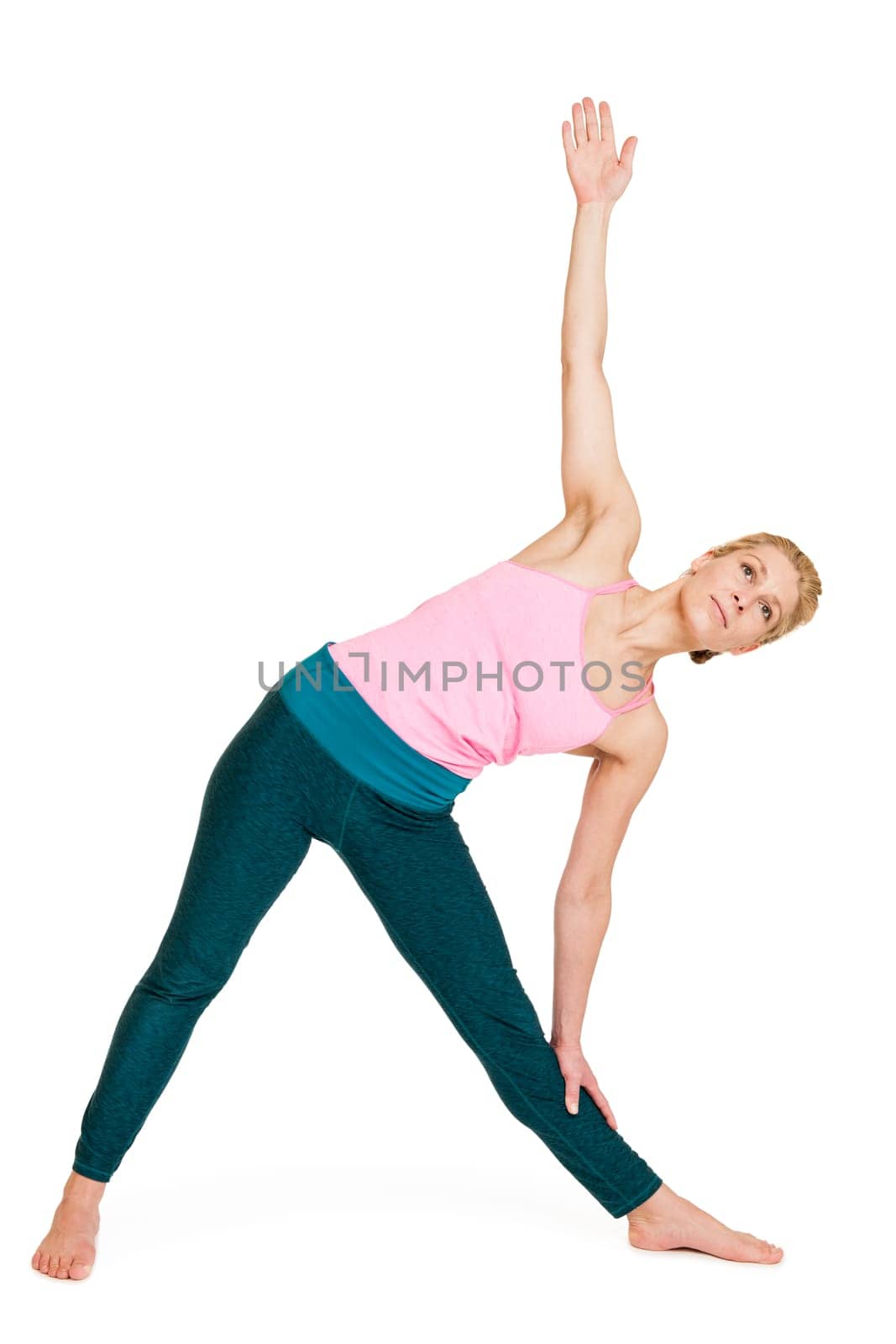 Lateral full-body view of a young woman during yoga exercise "Hero Triangle"" (Trikonasana) against a white background with a slight shadow"