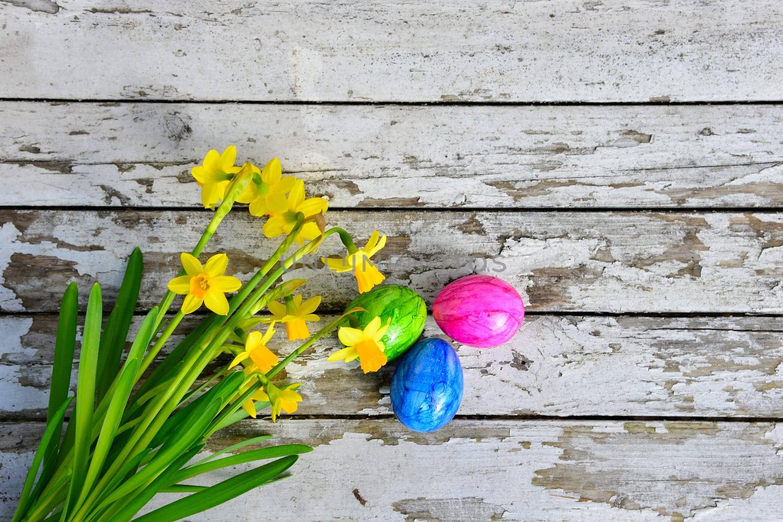 Easter bells and Easter eggs on old white wood background
