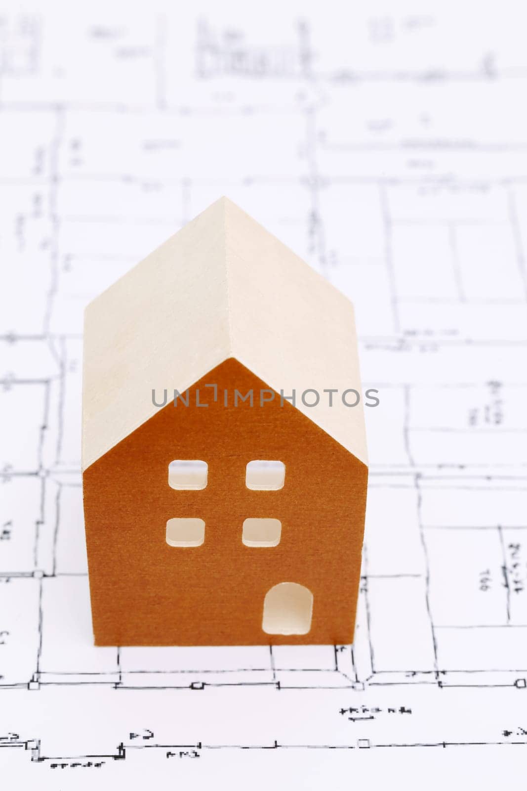 Wooden model of house on blueprints