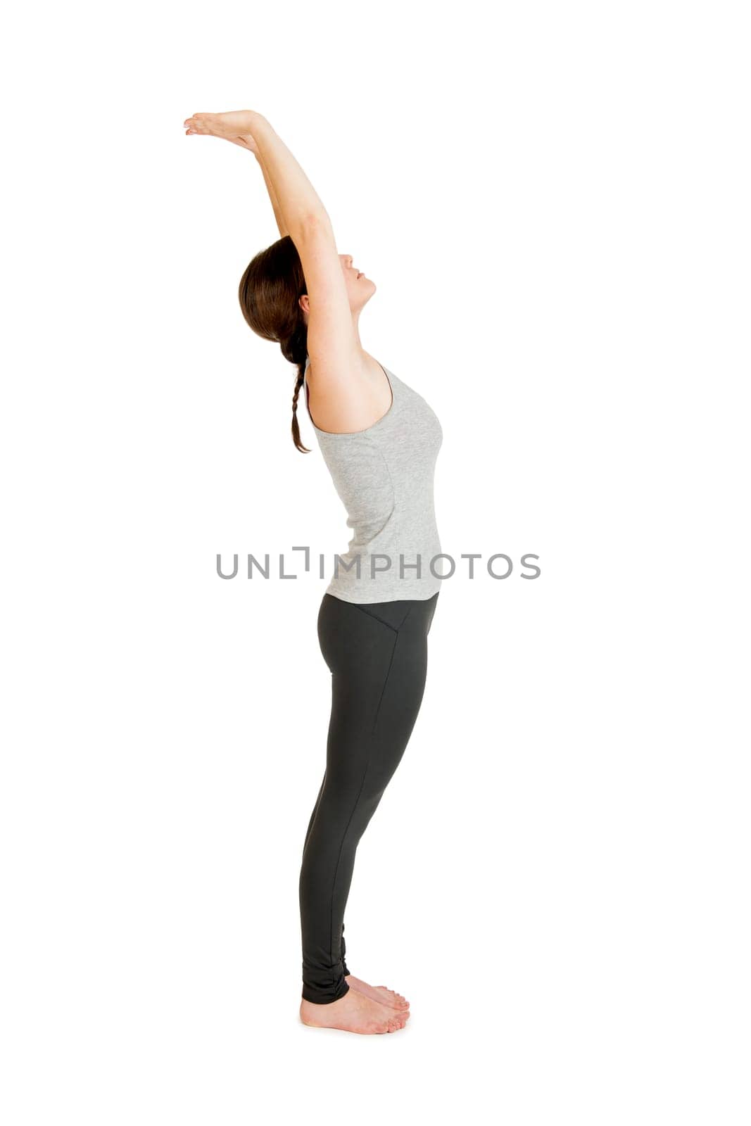 Full-body view of a young black-haired woman during yoga exercise "Standing Prevention"" Step 2 against a white background with a slight shadow"