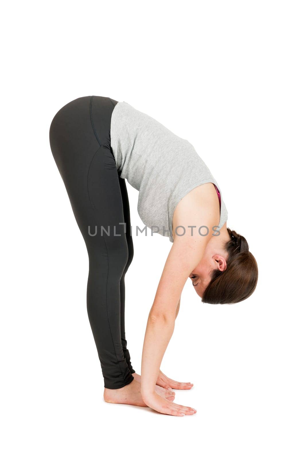 Full-body view of a young black-haired woman during yoga exercise "Standing Prevention"" Step 3 against a white background with a slight shadow"