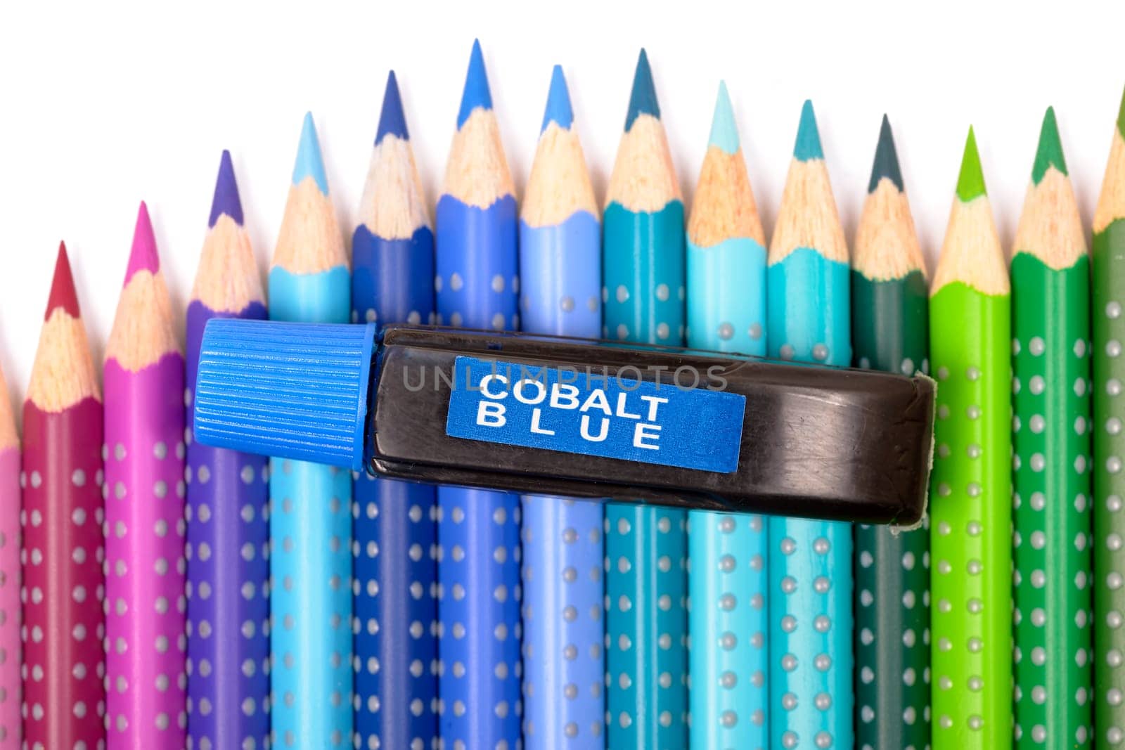 Bundle of colored pencils and tubes of paint on the colorful background
