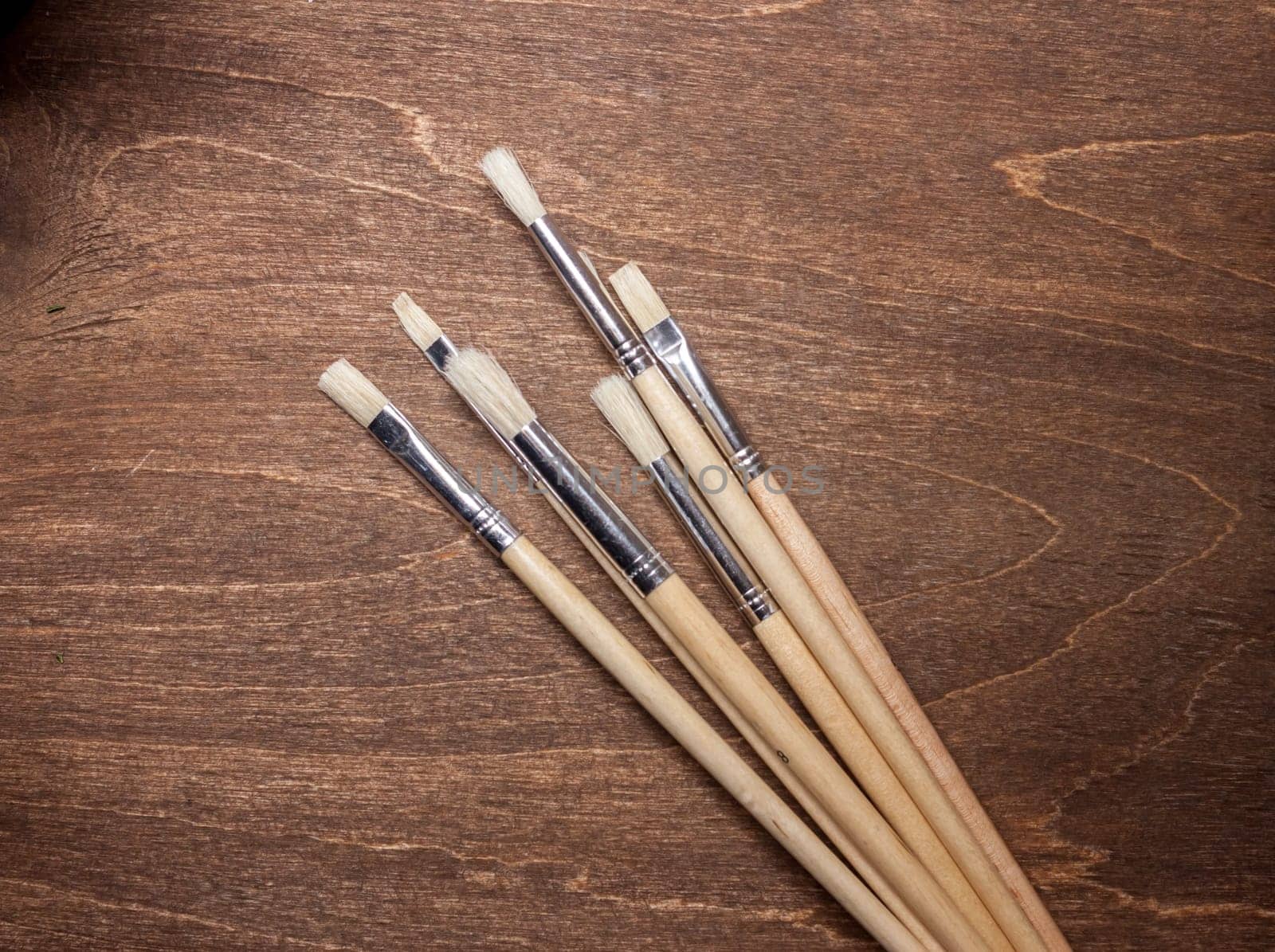 bunch of brushers on brown wooden background