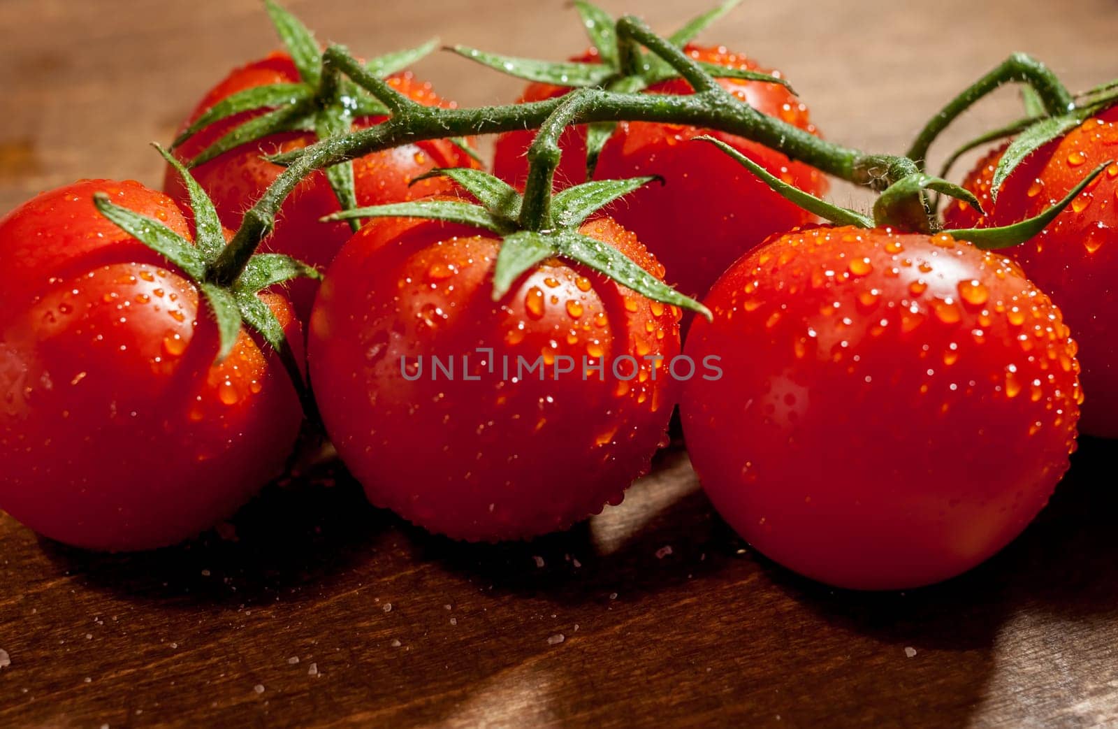 fresh ripe wet cherry tomatoes on wooden background
