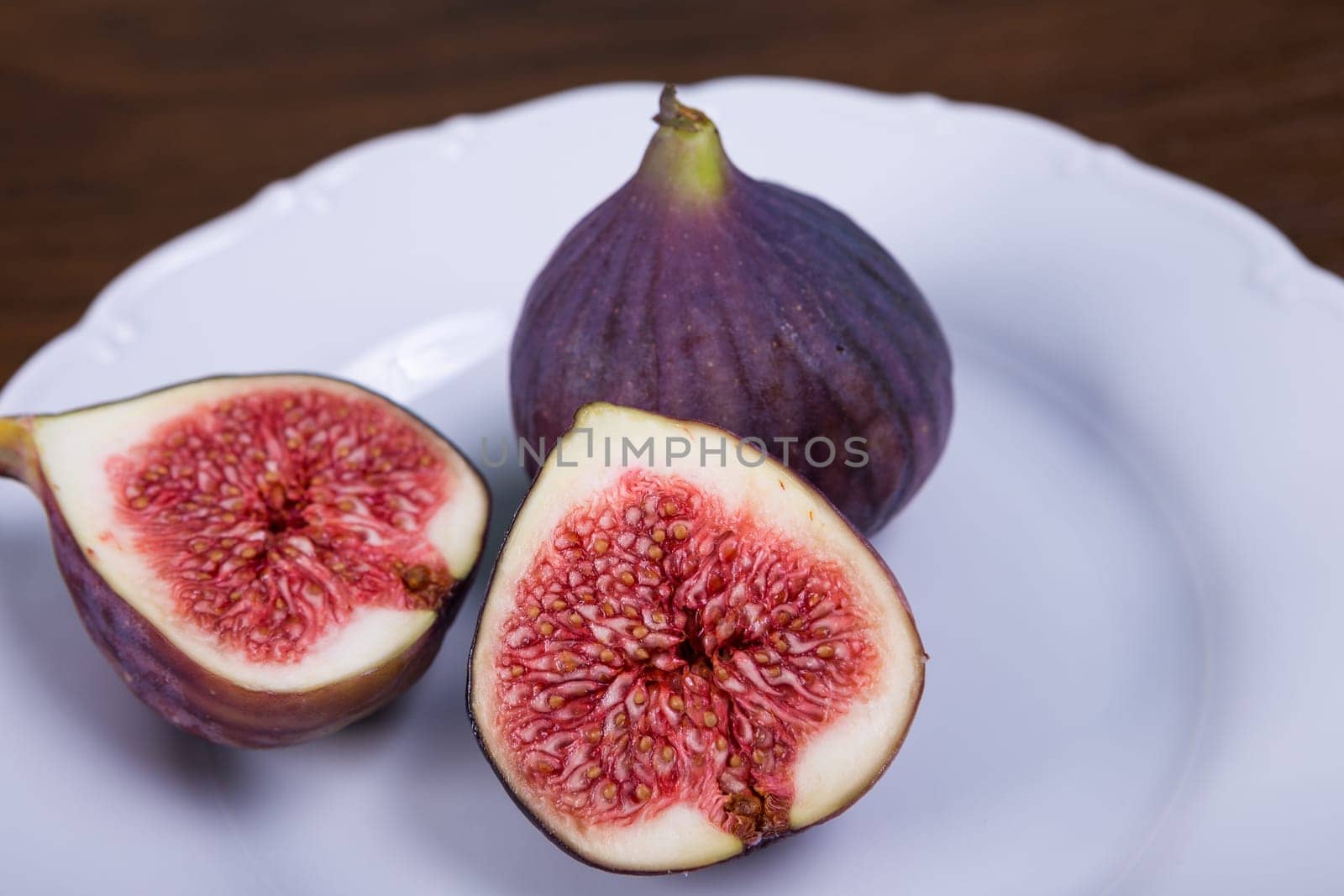 Fresh ripe figs on plate, exotic fruit close-up
