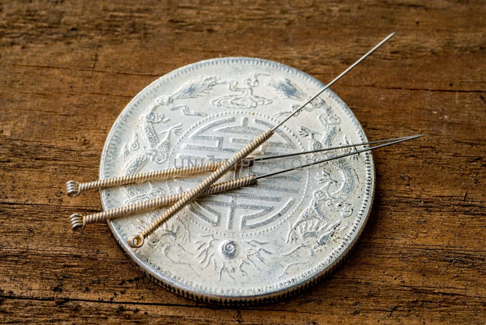 Acupuncture needle on antique Chinese coin