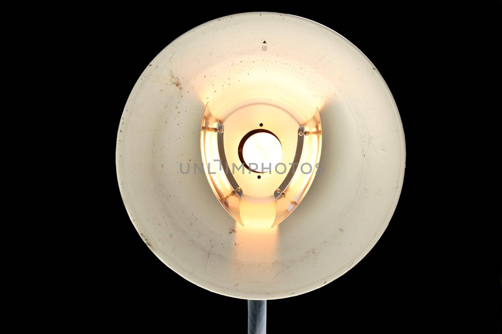 The lampshade of a exposed street lamp with light.