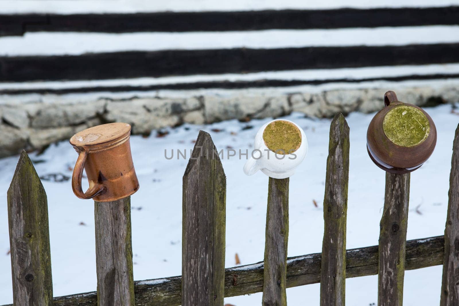Mugs and pots hanging on the wooden fence